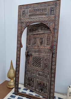 an intricately carved wooden door sits on a rug