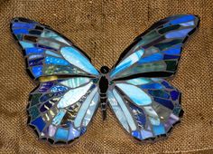 a blue butterfly sitting on top of a piece of fabric