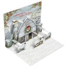 a christmas card with sheep in front of a barn