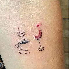 a woman's arm with a tattoo on it and a glass of wine in the middle