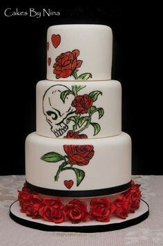 a three tiered cake decorated with roses and a skull on the bottom layer is shown