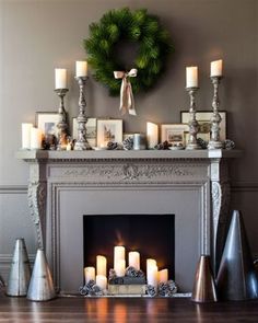 a mantel with candles and wreath on it