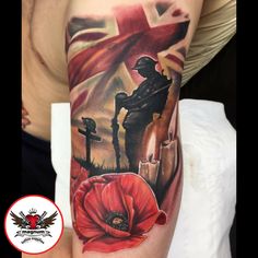 a man's arm with an image of a soldier holding a cross and poppys