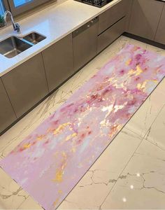 a pink area rug in a kitchen next to a sink and counter top with a window