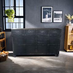 an industrial style storage unit in the corner of a room with black walls and windows