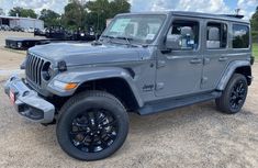 a gray jeep parked on top of a parking lot