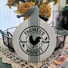 a sign that says farmers'local fresh market sitting on a doily with flowers in it