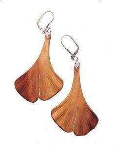 wooden earrings with metal hooks and wood leaves hanging from the earwires, on a white background