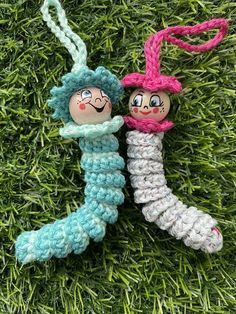 two crocheted dolls are hanging on the grass