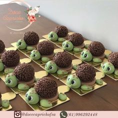 there are many small cakes made to look like turtles on the table together, with chocolate sprinkles in the shape of turtle heads