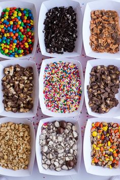 six white bowls filled with different types of cereals and candy bars on top of each other