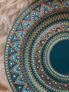 a blue and gold plate sitting on top of a white rug