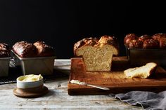 several loafs of bread sitting on top of a wooden cutting board next to each other