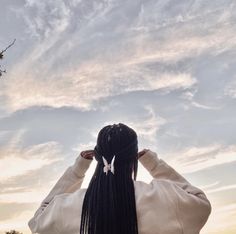 a woman with long braids looking up into the sky