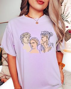 "Comfort Colors® Ancient Roman Sculpture Shirt, Roman Art Shirt, Renaissance T-Shirt, Michelangelo Tee, Art History Shirt, David Statue Shirt Welcome to NIOBE BOUTIQUE. I am happy to see you in my shop. My main purpose is to meet you with a high-quality product. I use the best product to make you happy. Your satisfaction is my priority. Placing an order is simple! *Please review all images in this listing for style, color, and sizes. *Select your t-shirt color and size from the drop-down menus. Purple Summer Tops With Graphic Design, Summer Purple Tops With Graphic Design, Purple Tops With Custom Print For Summer, Purple Graphic Tee With Custom Print, Ancient Roman Sculpture, David Statue, Roman Statue, Roman Sculpture, Art Shirt