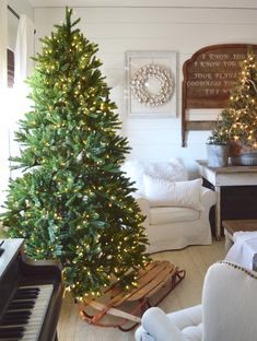 a living room with a christmas tree and piano