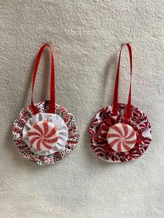 two red and white christmas ornaments hanging on a wall