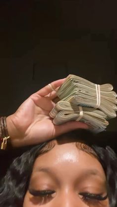 a woman holding stacks of money up to her head