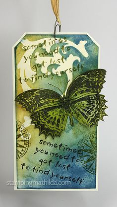 a tag hanging from a string with a butterfly on it's side and words written in the middle