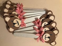 there are many brown teddy bears on the clothes pins with red and white bow ties