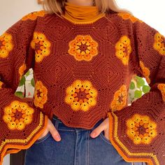 a close up of a person wearing a sweater with crocheted flowers on it