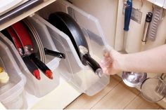 a person is holding scissors in their kitchen drawer