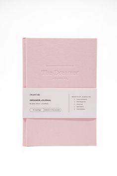 a pink notebook sitting on top of a white table