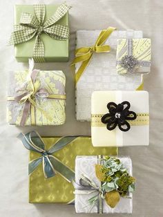 four wrapped presents with ribbons and bows on them, all in different patterns and colors