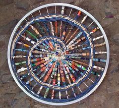 there is a circular metal object made out of colored crayons on the ground