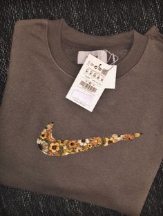 a t - shirt with a nike logo on the front and flowers on the back