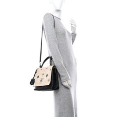 This is an authentic LOUIS VUITTON Calfskin Mechanical Flowers Lockme II in Black and Vanille. This stylish soft handbag is crafted of supple calfskin leather in black and off-white. The shoulder bag features a black leather top handle, black leather shoulder strap, floral embellishments with polished gold and silver hardware and a silver LV closure on the front flap. This opens to a partitioned black fabric interior with patch pockets. Louis Vuitton Crossbody Bag, Black Leather Top, Louis Vuitton Crossbody, Louis Vuitton Empreinte, Embroidered Monogram, Mini Roses, Lv Monogram, Black White Pink, Louis Vuitton Shoulder Bag