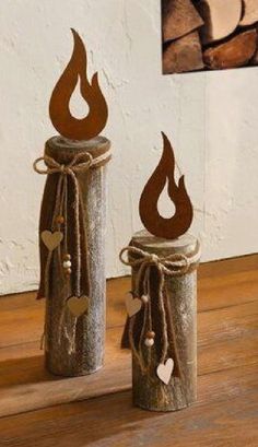 two metal canisters with hearts on them sitting on a wooden table next to firewood