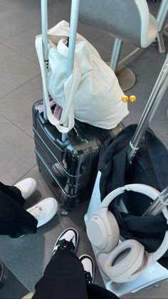 several pieces of luggage sitting on the ground with headphones and other items around them