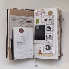 an open book with papers and stickers on the pages that are covered in paper