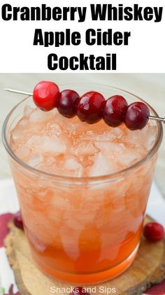 cranberry whiskey apple cider cocktail in a glass with ice and cherries