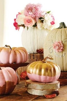 some pink and gold pumpkins are sitting on a table