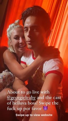 a man and woman sitting next to each other in front of an orange curtain with the words about to go live with