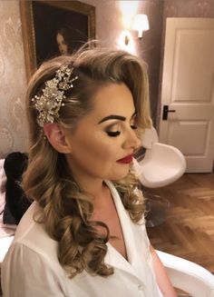 a woman with long hair wearing a white shirt and flower headpiece in her hair