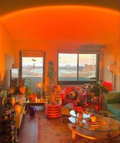 a living room filled with furniture and lots of windows covered in bright orange light from the sun