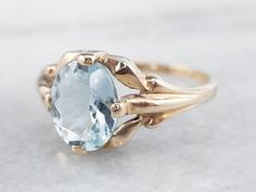 This stunning aquamarine has been set into this Retro era solitaire ring. The cool blue tones contrast beautifully with the warmth of the vintage mounting, while the tapered shoulders draw light into the sparkling gem. This is a lovely piece that is pretty enough to wear alone, yet versatile enough to stack with other rings!Metal: 10K Yellow GoldGem: Aquamarine 1.37 CaratsGem Measurements: 8.5 x 6.9 mm, OvalRing Size: 5.25Marks: "10K" Stamped on the inside band Fine Jewelry Light Blue Sapphire Ring For Formal Occasions, Light Blue Sapphire Ring For Formal Occasions, Formal Light Blue Topaz Ring, Vintage Aquamarine Rings For Formal Occasions, Vintage Aquamarine Gemstone Rings, Classic Topaz Ring With Diamond Cut, Vintage Oval Aquamarine Ring, Vintage Aquamarine Oval Ring, Classic Aquamarine Rings For Formal Occasions