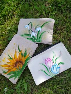 three hand painted sunflowers are sitting on the grass