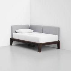 a bed that is sitting in the middle of a room next to a white wall