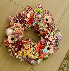 a christmas wreath made out of candy canes and other decorations sits on the floor