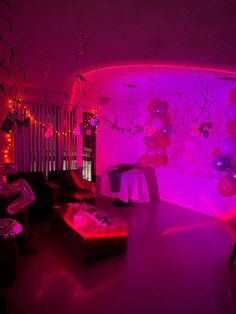 a living room filled with furniture and balloons on the wall above it's purple lights