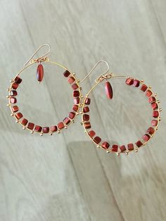 3" long and 2" wide hoop earrings featuring hand wire wrapped goldstone and gold filled beads.  The goldstone is man made. It resembles sunstone but is darker and richer. The color is like copper penny. It is square shaped with the holes drilled crosswise, corner to corner. It measures 5mm. The squares are hand wire wrapped onto the hoop frames on the inside of the hoop. I wrapped 2.5mm gold filled beads around the outside of the hoops. Hanging from the middle of the hoop at the top is a large rice shaped goldstone bead which measures 5.5mx12m.  The wire, round beads and earwires are 14k gold filled. The earwires are handmade. The hoop frame is gold plated over stainless steel.  These earrings are really light and comfortable. The color combination is incredible. I can't wait to design a m Wire Wrapped Yellow Gold Hoop Earrings, Gold Wire Wrapped Copper Hoop Earrings, Multicolor Small Hoop Beaded Earrings Wire Wrapped, Gold Wire Wrapped Hoop Crystal Earrings, Wire Wrapped Multicolor Hoop Earrings, Copper Penny, Corner To Corner, Beaded Hoops, Matching Necklaces