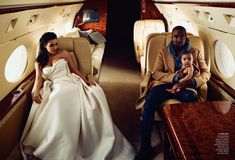 a man and woman are sitting in an airplane with their baby on the table next to them