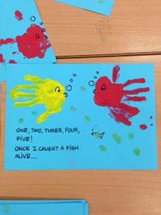 two handprinted cards with red and yellow fish on blue paper next to each other