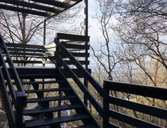 there is a set of stairs leading up to the top of a hill with trees in the background