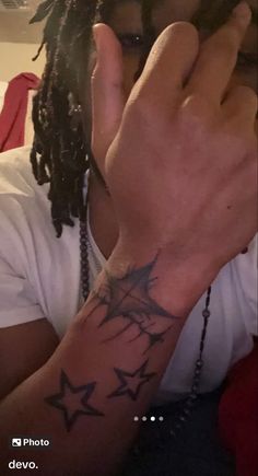 a man with dreadlocks covering his face and holding his hand up to his ear