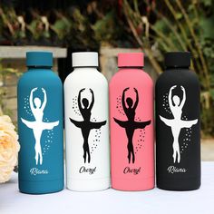 three water bottles with different designs on them sitting next to a bouquet of pink flowers